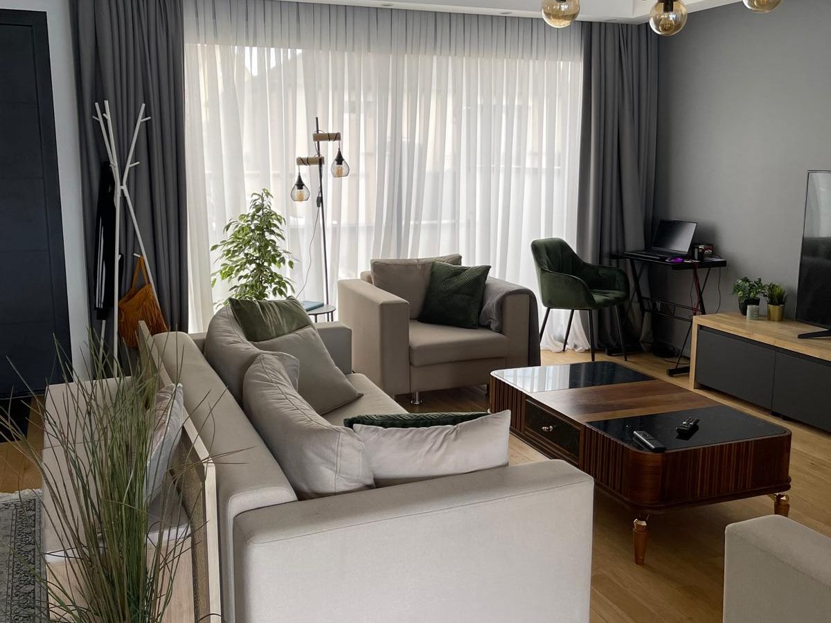 Séjour rénové avec parquet et suspension contemporaine